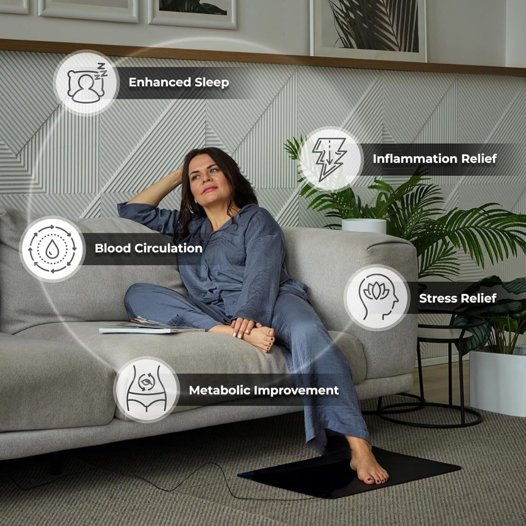 Woman sitting on a couch with grounding Mat with health benefits displayed around her