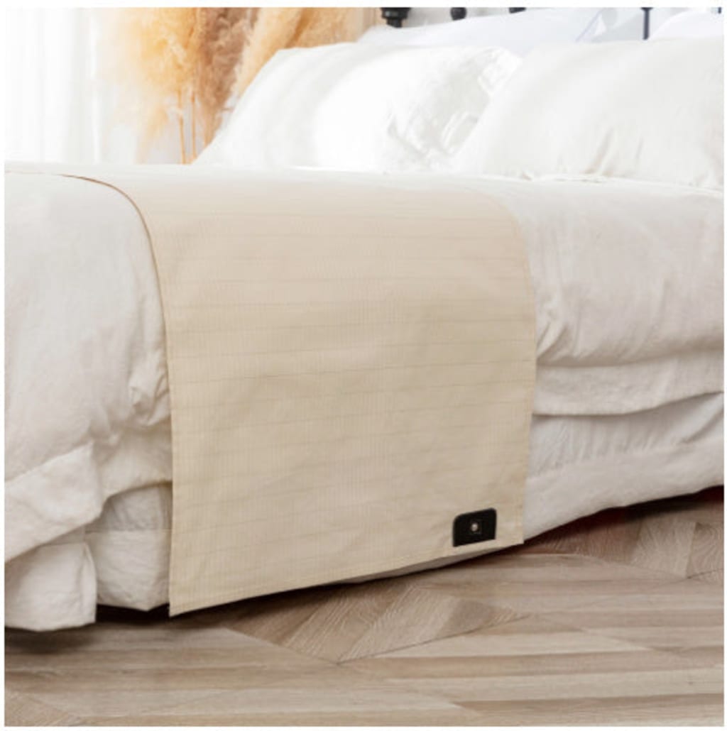 Rejuviaa grounding sheet on a bed with a wooden floor in the background